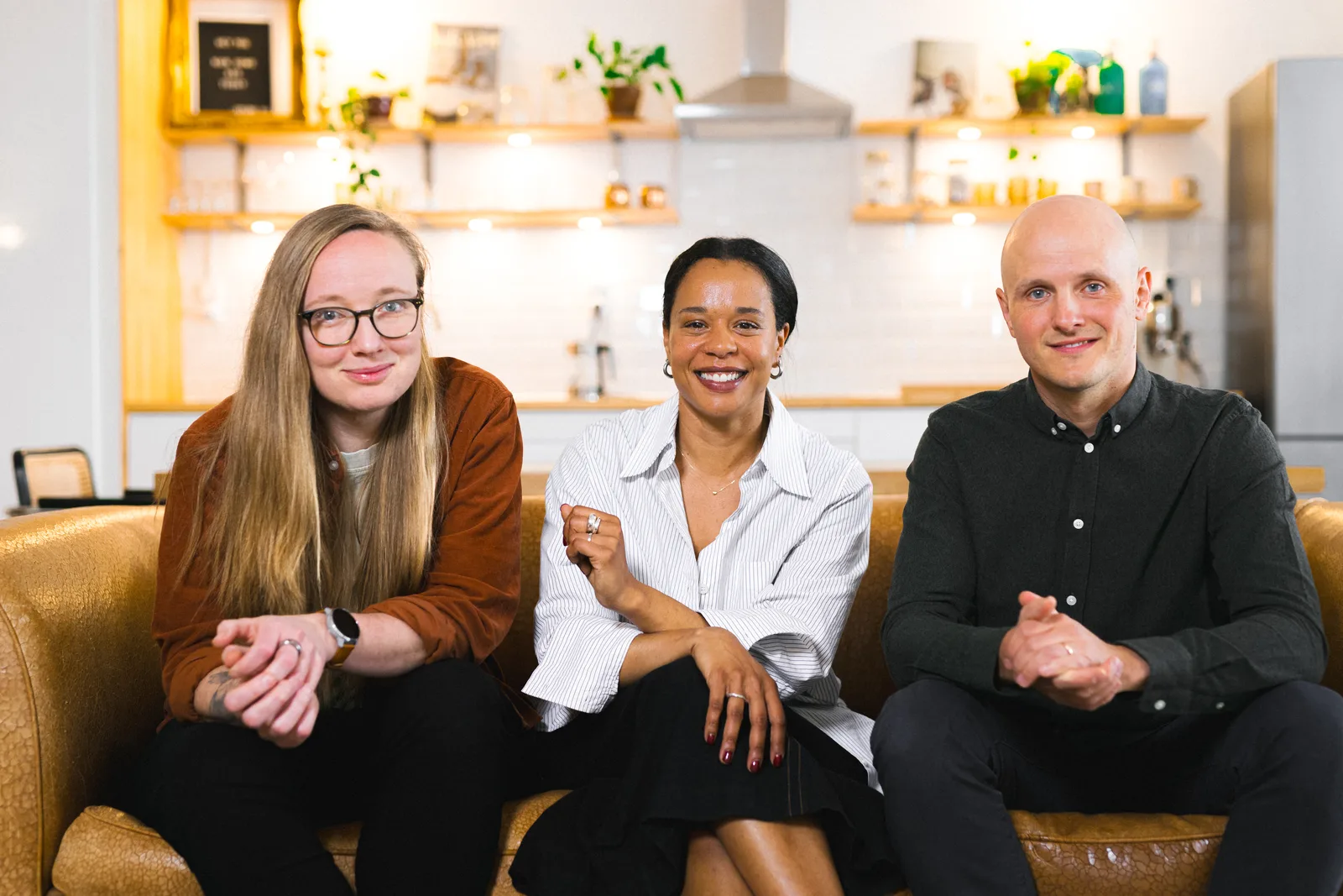 Three colleagues photographed in a warm office setting in Barcelona