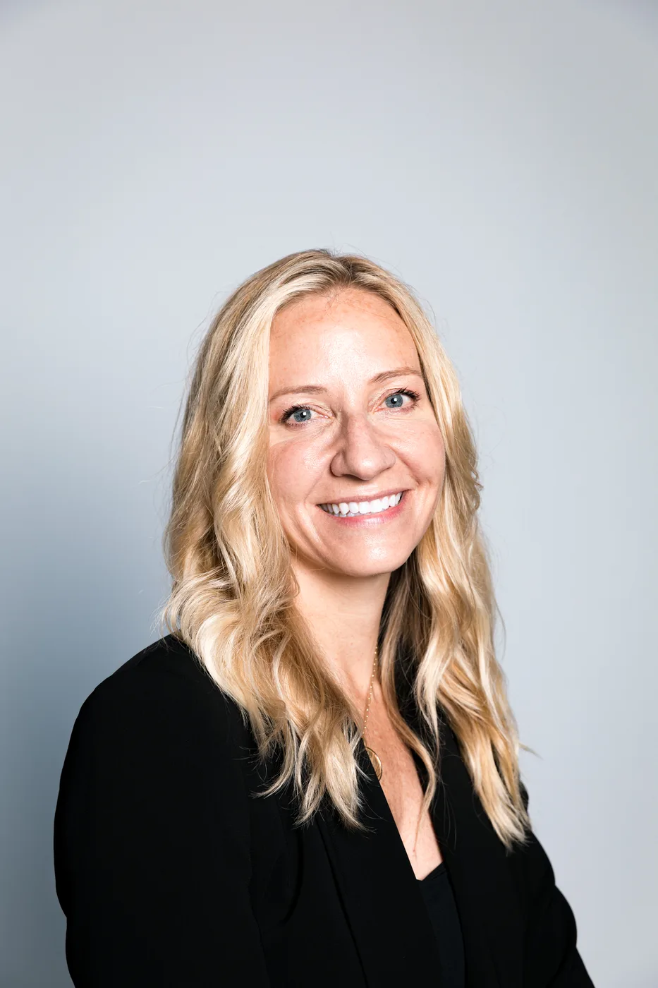 Professional headshot of a woman on a grey background